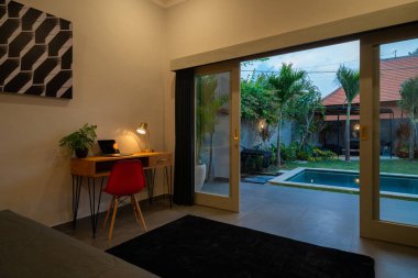 Lüks ve modern bilardo köşkünde yatak odasının iç tasarımı havuz manzarası, yeşil bahçe, güneşlik ya da güneşlik havuz terasında, mavi yastık yatak ve lamba ve sürgülü kapı içerir.