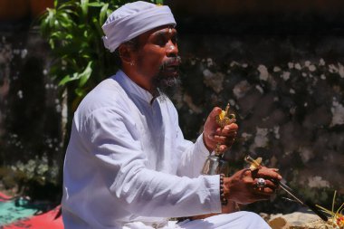 Dua sırasında bir Balili pedanda 'nın yanına yaklaş. Bir Hindu rahibin tören yaparken yan görüntüsü. Endonezya, Bali 'deki Pemuteran tapınağında adak adamış bir Hindu rahip.