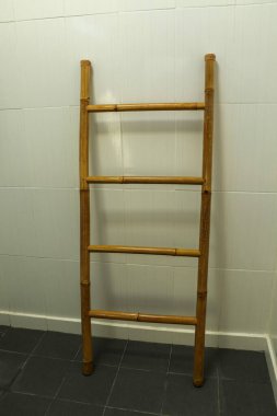 Gri zeminde tahta havlu askısı merdiven banyosu.