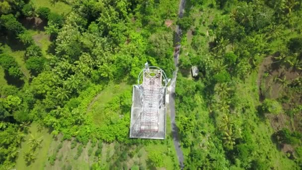 Vista aérea giratoria de las torres de telecomunicaciones 5G de pie sobre densas montañas verdes contra la hermosa luz del sol — Vídeos de Stock