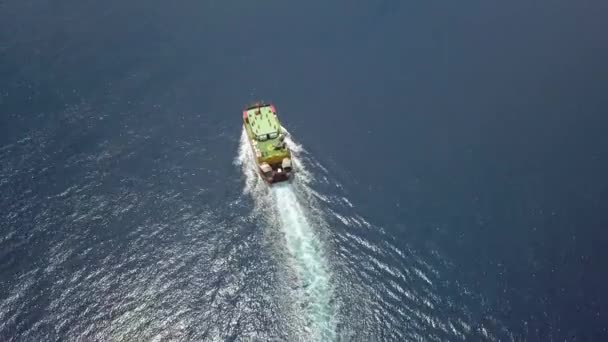 Färja på havet, som transporterar bilar: däck på en båt som transporterar fordon. Sommarsol reflekterar bort den krusade vattenytan av sjön eller floden avslöjar vågor konsistens. Flyg ovanifrån från från en drönare — Stockvideo