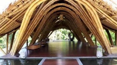 Ubud, Bali 'de kamış çatılı bir bambu kulübesinin içinden uç. Kuru saman ve samanla dolu büyük bir evin çatısı. Bambu tavanlı güneş ışığı