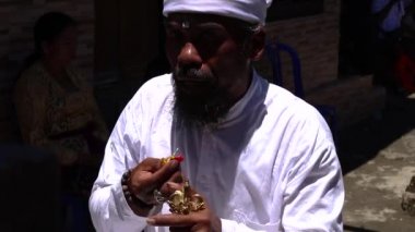 Balili rahip bir şeyler çağrıştırıyor ve ölü ataları anma ayinini gerçekleştiriyor. Ölülere hürmet. - Yakın çekim. Rahip, Endonezya 'da ayin yapıyor.