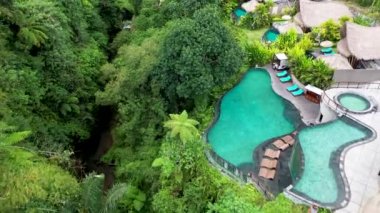 Etrafta bir sürü ağaç olan havuzu olan bir vila.