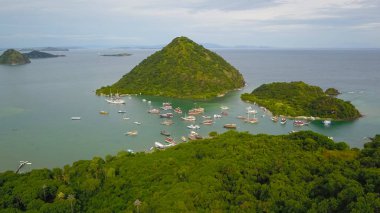 Padar adası Labuan Bajo 'nun etrafında yelken açan geleneksel fenisi hava manzaralı bir grup..