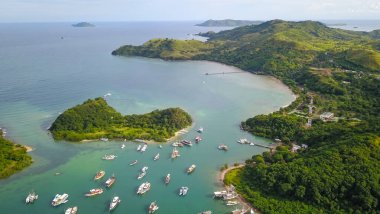 Padar adası Labuan Bajo 'nun etrafında yelken açan geleneksel fenisi hava manzaralı bir grup..