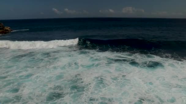 大浪从上方滚来 蓝色碧绿的大海 浪花汹涌 雪白的海水 自上而下的4K无人机视野 阳光灿烂的日子在海面上 巨大的海浪冲击着海岸线 强烈的海浪巴厘印度尼西亚 — 图库视频影像