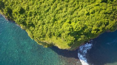 Turkuaz denizle çevrili tropikal adanın havadan görünüşü. Gili Selang Bali 'de tropikal bitki örtüsüyle kaplı küçük bir ada..