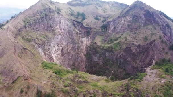 Vista aérea de cerca del cráter Batur. Mirando por encima del borde de un volcán activo en el cráter mientras el vapor se eleva desde un respiradero muy por debajo. Vista interior de la caldera del Monte Batur, Bali. — Vídeos de Stock