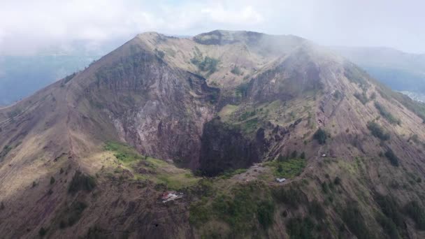 Περιστρεφόμενο κηφήνας μέρος του χωριού στην κορυφή του βουνού. Batur ακρολοφία στο Μπαλί, Ινδονησία με ομίχλη που καλύπτει την πόλη στους πρόποδες του βουνού — Αρχείο Βίντεο
