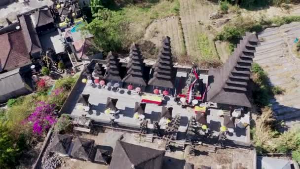 Drohnen-Blick auf die Treppe. Aufsteigender Sockel Luftaufnahme atemberaubender schwarzer Steinsäulen und farbenfroher Statuen am Pura Pasar Agung Hindu Tempel auf der Seite des Berges Batur auf Bali — Stockvideo