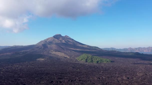 Górski krajobraz skały pokryte zieloną roślinnością, drzewa z wulkanem batur nieba i chmury Bali, Indonezja. Koncepcja podróży. Nagrania lotnicze — Wideo stockowe