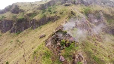 Batur Dağı, Bali, Endonezya 'nın içindeki bir bacadan buhar yükseliyor. Aktif bir volkanın kalderasının içinde yürüyüş yapmak. Popüler turist eğlencesi. Duman ve gazlar volkandan çıkıyor.