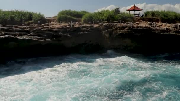 Onde marine selvagge e belle su una linea costiera nera durante mattina di tempo lunatico. Onde si infrangono su edifici e pietre rocciose situati proprio su una riva di una spiaggia — Video Stock