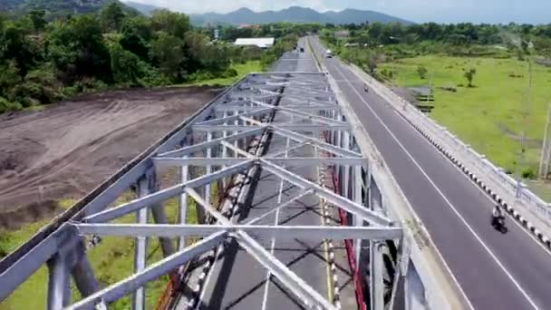 Verfolgungsjagd mit Autos auf einer Stahlbrücke auf Bali, Indonesien. Drohnenblick aus der Luft — Stockvideo