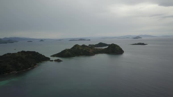インドネシアのラブアン・バジョのフローレス島沖の牧歌的な島の空中ドローン映像。前方の動きで撃たれた — ストック動画