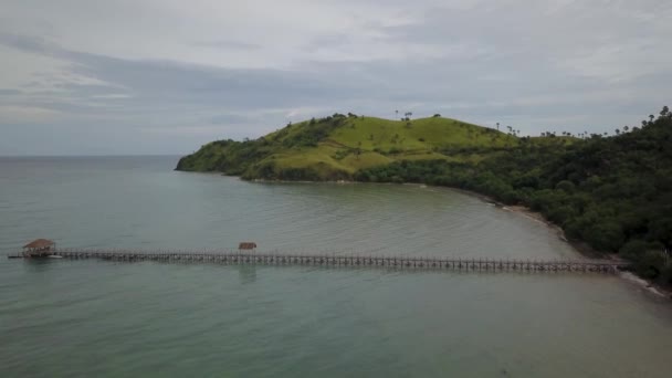 Menakjubkan pemandangan udara air laut pirus dengan dermaga kayu di pantai Labuan Bajo, Pulau Flores sebuah pulau yang terletak di dekat Bali, Indonesia. Ditembak dalam resolusi 4k — Stok Video