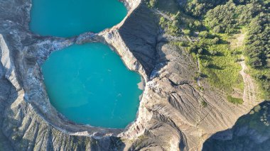 Havadan bakıldığında, Flores volkanik güzelliğini gösteren sarp kayalıklar ve yemyeşil yeşilliklerle özetlenmiş Kelimutu ikiz krater gölleri görülüyor..