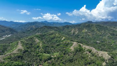 Flores boyunca uzanan görkemli tepeler ve güneşli vadiler, rüya gibi beyaz bulutlarla dolu bir gökyüzünün altındaki yemyeşil araziyi çevreleyen dağınık köyler..