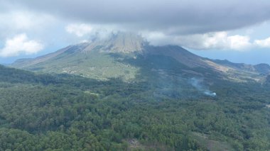 Girdap gibi bulutların taçlandırdığı görkemli Inerie volkanı, dumanlı yamaçları zümrüt ormanlarına düşüyor. Flores 'in vahşi kalbine bir göz atan nefes kesici bir dron..
