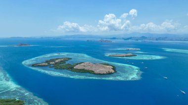 Komodo Ulusal Parkı 'nın hava manzarası, parlayan turkuaz lagünlere sarılı engebeli bir adayı gözler önüne seriyor. Dalgıç teknelerinin gelişen mercan bahçelerinin üzerinde sürüklendiği bir ada..