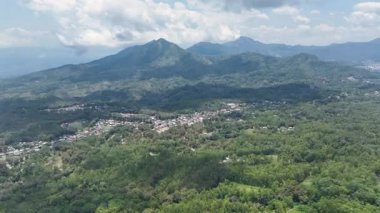 Ormanlarla çevrili bir stadyumun havası Bajawa ormanlı tepelerin arasına yerleşmiş, Inerie volkanik zirvesi Flores 'in ufkunu delip geçiyor..