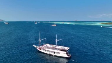 Plajların, turistik teknelerin ve Kelor Adası 'ndaki ahşap iskele, Komodo Ulusal Parkı, Labuan Bajo, Endonezya.