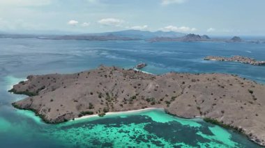 Canlı mercan desenleri Komodo 'nun altındaki turkuaz sığlıkları boyarken, dağılmış adalar ve uzak uyanışlar etraftaki gizli dalış noktalarını işaret ediyor..