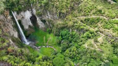 Yukardan aşağıya, Sispiso Piso şelalesi ağaçların arasından neon yeşil bir kanyona dökülen sıvı ipek gibi görünüyor..