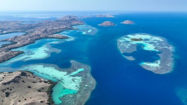 Engebeli Komodo kıyıları turkuaz göllerle ve açık gökyüzünün altında uzak adalarla buluşuyor..