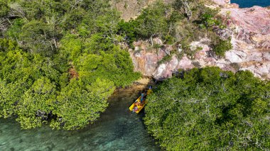 Çilek Kayası 'nda yoğun yeşil mangrovlar gizli bir turkuaz lagün çerçevesi oluşturuyor. Parlak sarı tekneli turistler kristal sığ sularda süzülüyor. Pembe ve paslı uçurumlar dramatik bir şekilde suyun üzerinde yükselir..