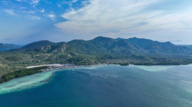 Bereketli yarımada, katmanlı yeşil volkanik tepelerin desteklediği küçük bir köyün yakınındaki turkuaz sığlıklarıyla derin mavi denize doğru kıvrılır...