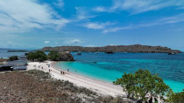 Turkuaz dalgalar Komodo efsanevi Pembe Kumsalı 'nın yumuşak pembe kumlarını öperken sürüklenen tekneler ve engebeli adalar bu dokunulmamış tropikal cenneti tamamlıyor..