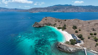 Yukarıdan bakıldığında, Pembe Kumsal, Komodo 'nun kuru yamaçları boyunca pastel bir kurdele gibi kıvrımlıdır. Mercan zengini sığ suları mavi tonlarda parıldar..