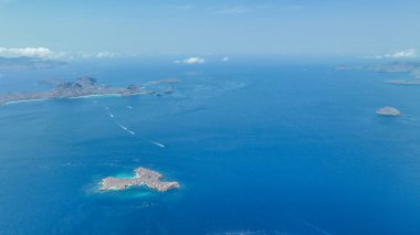 Yalnız Padar Adası mücevheri Komodo 'da süzülür. Uçsuz bucaksız mavi engin, turkuaz sığ ve sonsuz denizi parçalayan dalgalanma izleri ile süslenir..