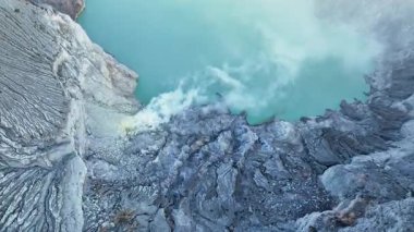 Alçalmanın en üst görüntüsü aktif Ijen volkanındaki asit gölüne iniyor. Turkuaz su, sülfür buharı buhar bulutu. Gezgin şehvet kavramı, vahşi doğa, milli park zamanı..