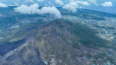 Geniş Batur Caldera Panoraması. Turkuaz göl engebeli tepelerle bezenmiş, antik lav tarlaları Bali 'nin sonsuz gökyüzünün altında karanlık volkanik ovalara yayılmış..