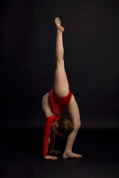 Girl gymnast on a black background — Stock Photo, Image