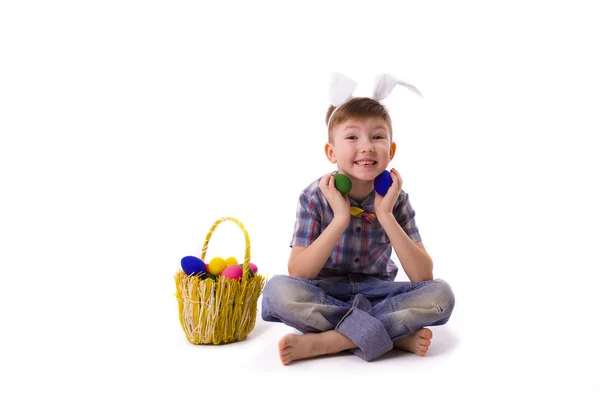 Niedlicher kleiner Junge im Bild eines Osterhasen mit Eiern — Stockfoto