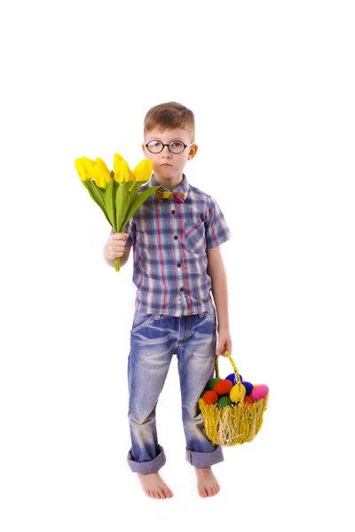 Grappige jongen met een boeket tulpen en Pasen mandje met eitjes — Stockfoto