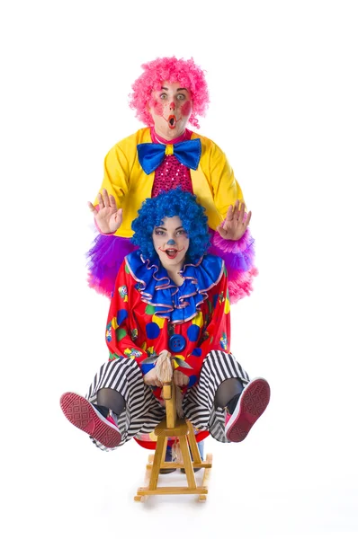 Два смішних барвистих клоуна, що обманюють навколо на білому тлі — стокове фото