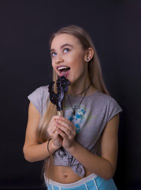 bir lolipop siyah bir arka plan ile bir kız portresi