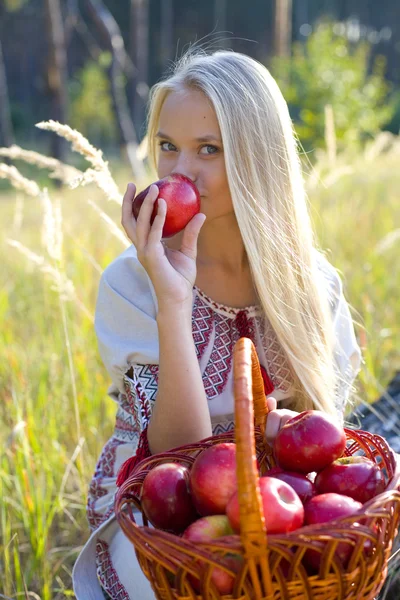 Schönes Mädchen mit einem Korb voller Äpfel — Stockfoto