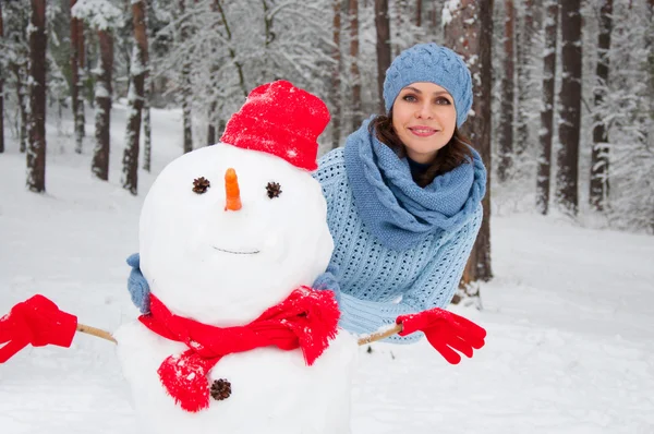 Retrato engraçado de uma menina com um boneco de neve — Fotografia de Stock