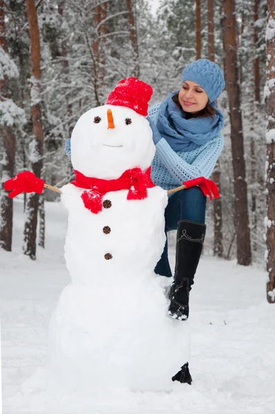 Lustiges Porträt eines Mädchens mit einem Schneemann — Stockfoto