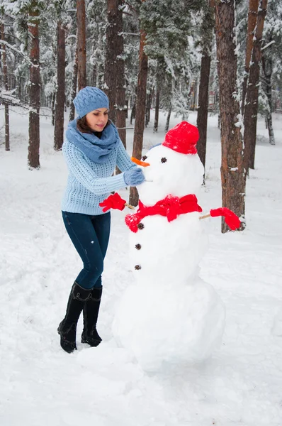 Lustiges Porträt eines Mädchens mit einem Schneemann — Stockfoto