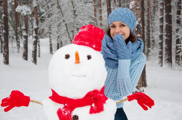 Lustiges Porträt eines Mädchens mit einem Schneemann Stockbild