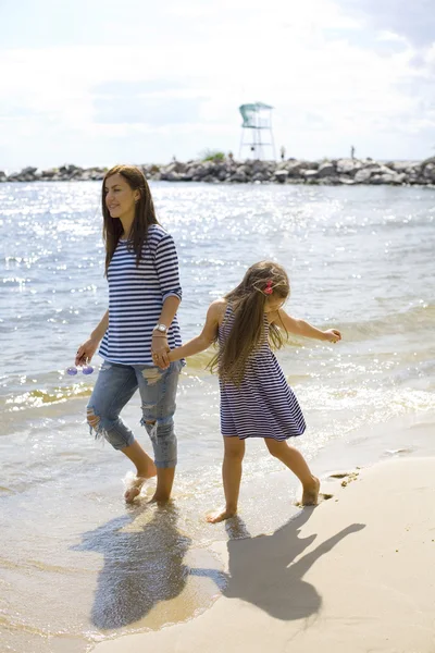 母亲和女儿沿着海边散步 — 图库照片