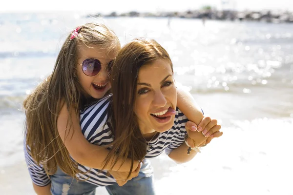 Alegre e positiva mãe e filha perto do mar — Fotografia de Stock