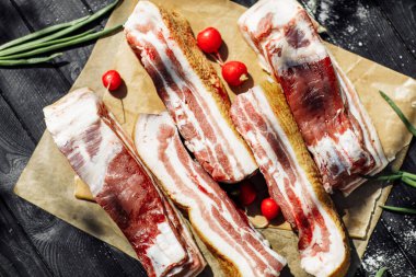 Ahşap bir masada taze otlar ve aromatik baharatlarla dilimlenmiş füme tavla. Geleneksel yöntemlerle üretilen organik tarım ürünleri.